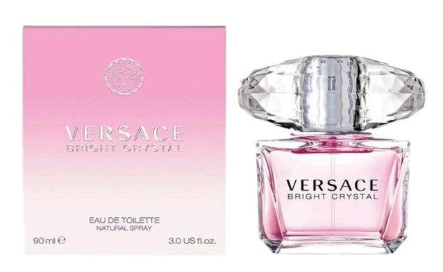A pink bottle of perfume next to the box.