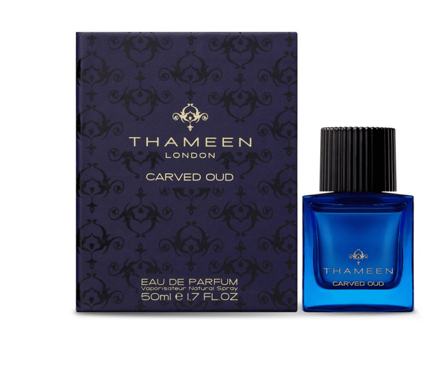 A blue bottle of perfume next to its box.