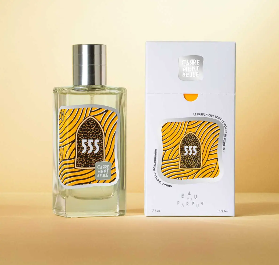 A bottle of perfume next to its box.