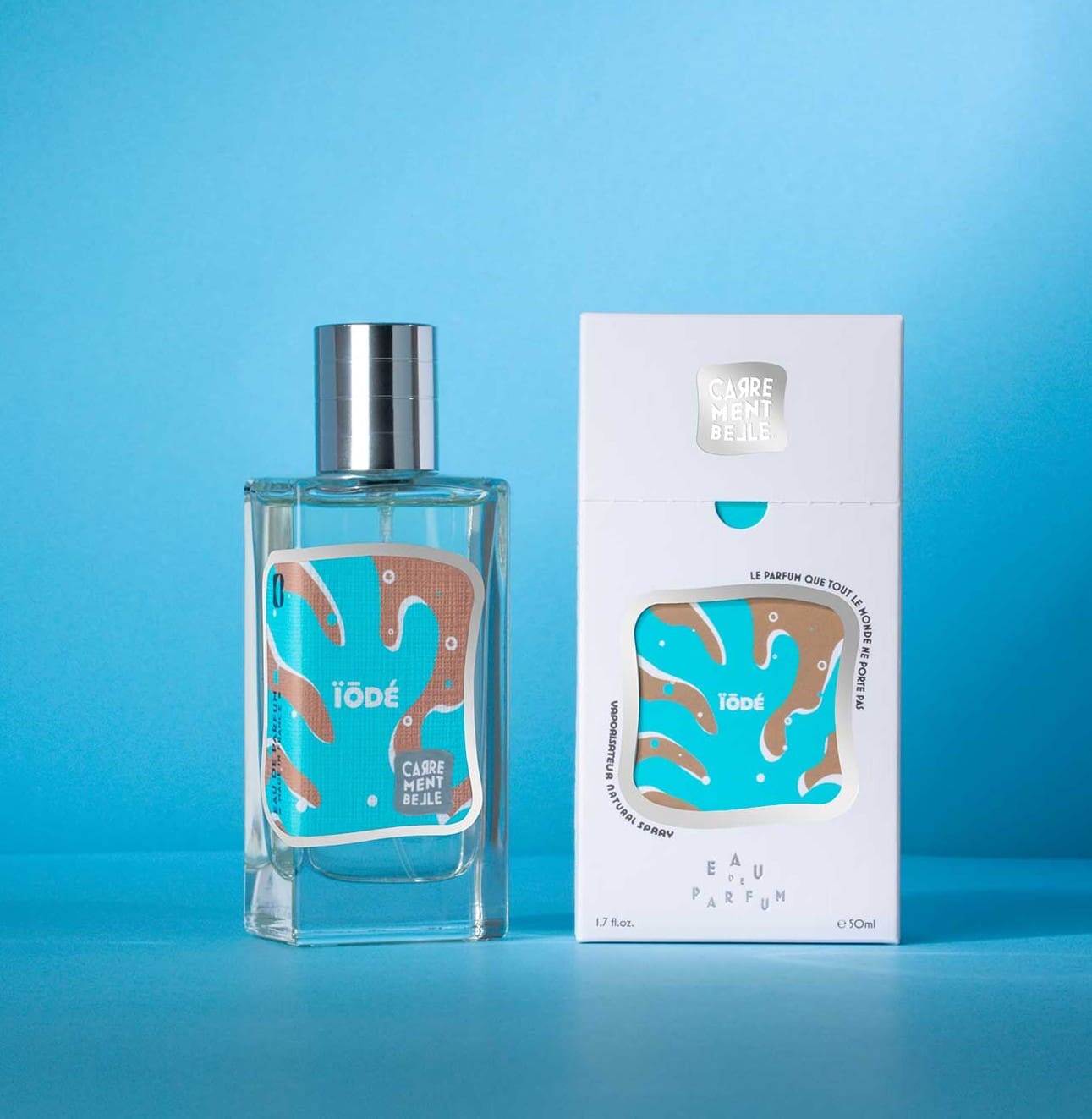 A bottle of perfume next to its box.